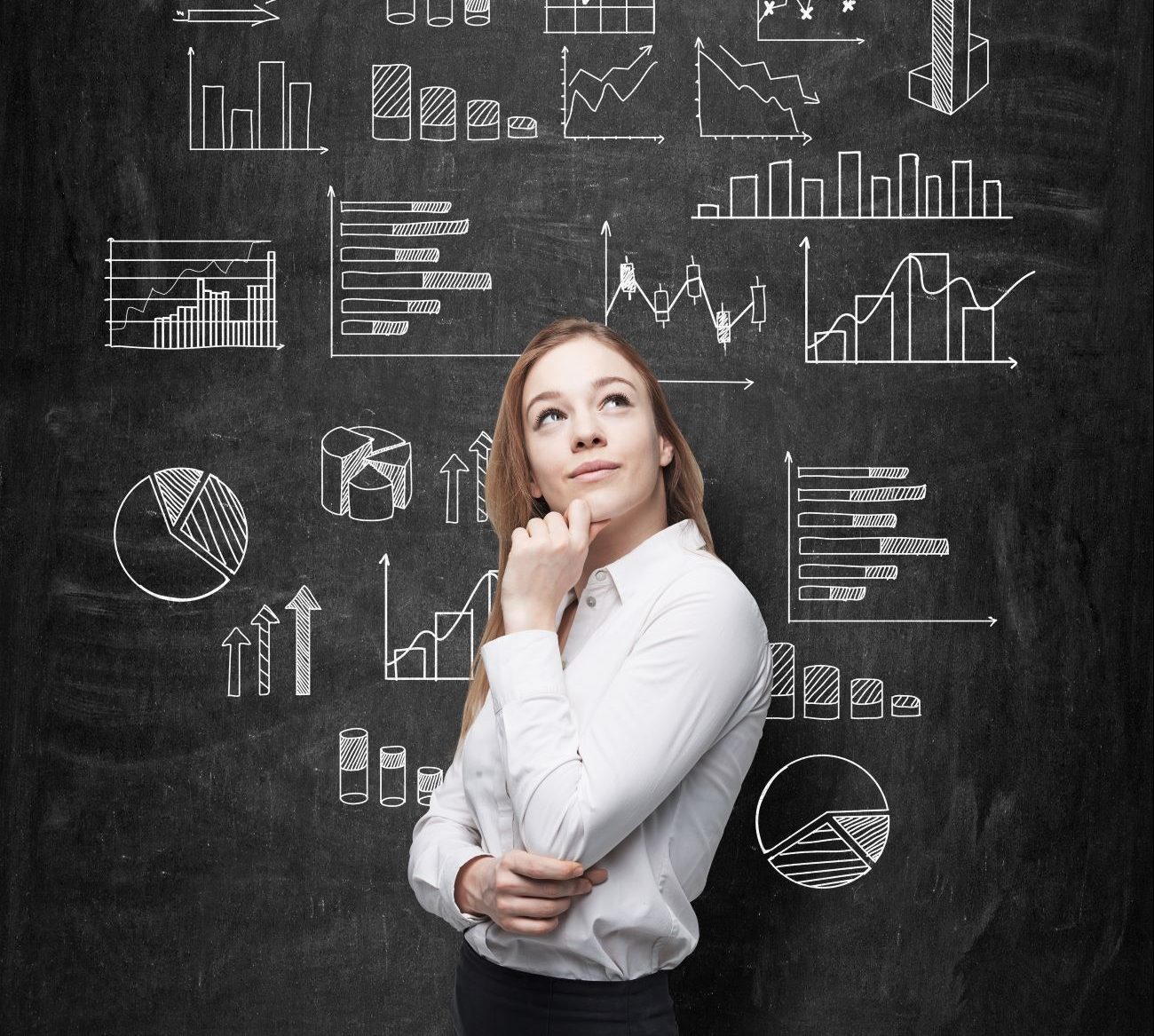 Woman standing in front of charts on chalkboard